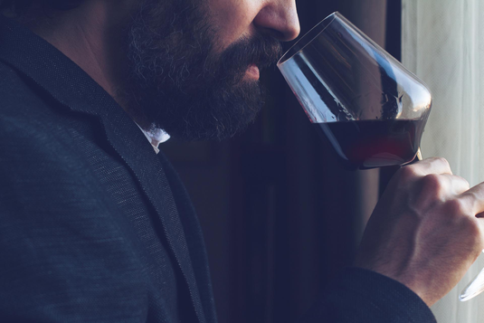 Ein Mann riecht an einem Glas mit hochwertigem Rotwein
